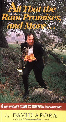 Cover of All That the Rain Promises and More featuring the author, a white man in a tux, holding a trumpet and a bunch of mushrooms