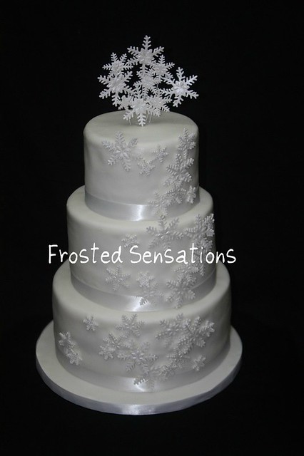 3 tier winter wonderland wedding cake with cascading snowflakes and a