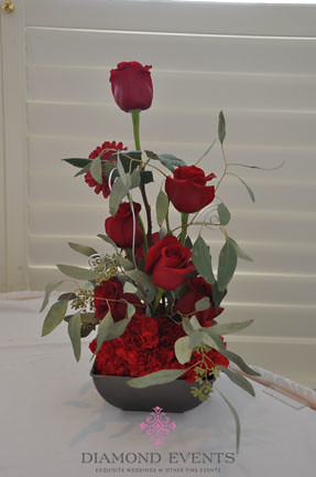 Tall Red floral arrangement in a low container by Diamond Events