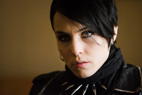 Lisbeth Salander, a white woman with short black hair, looks just off camera. She is wearing eyeliner.