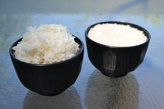 Compose a photograph that includes a 'finished product' and at least one of its 'raw materials'. Cooked rice & Uncooked rice