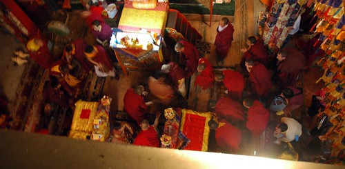 From above: His Holiness Dagchen Rinpoche getting ready to leave Tharlam Monastery shrine room, all bow, monks, lamas, his son, grandson, disciples, Tibetan Buddhism, decorations, throne, drum, Boudha, Kathmandu, Nepal by Wonderlane