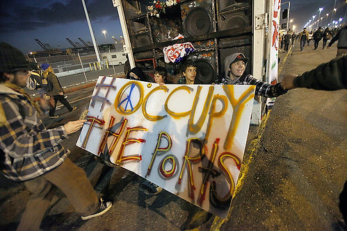 Several protesters ride on the back of a truck as thousands of Occupy Oakland protesters march to the Port of Oakland on Monday, Dec. 12, 2011 in Oakland, Calif. They were planning to stay until the next shift began at the port at 3 a.m. by Pan-African News Wire File Photos