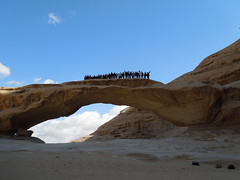 Students standing on top of a desert arch in Wadi Rum, Jordan, just outside of the Bedouin camps