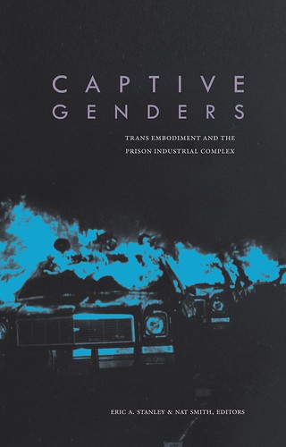 The cover of Captive Genders, which is black with a photo of cop cars on fire in blue