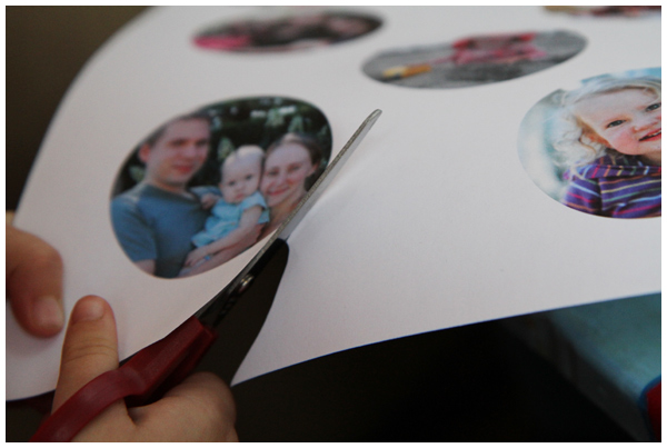 Kid using scissors to cut out circular family photos