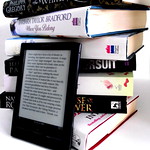 eReader next to stack of paper books