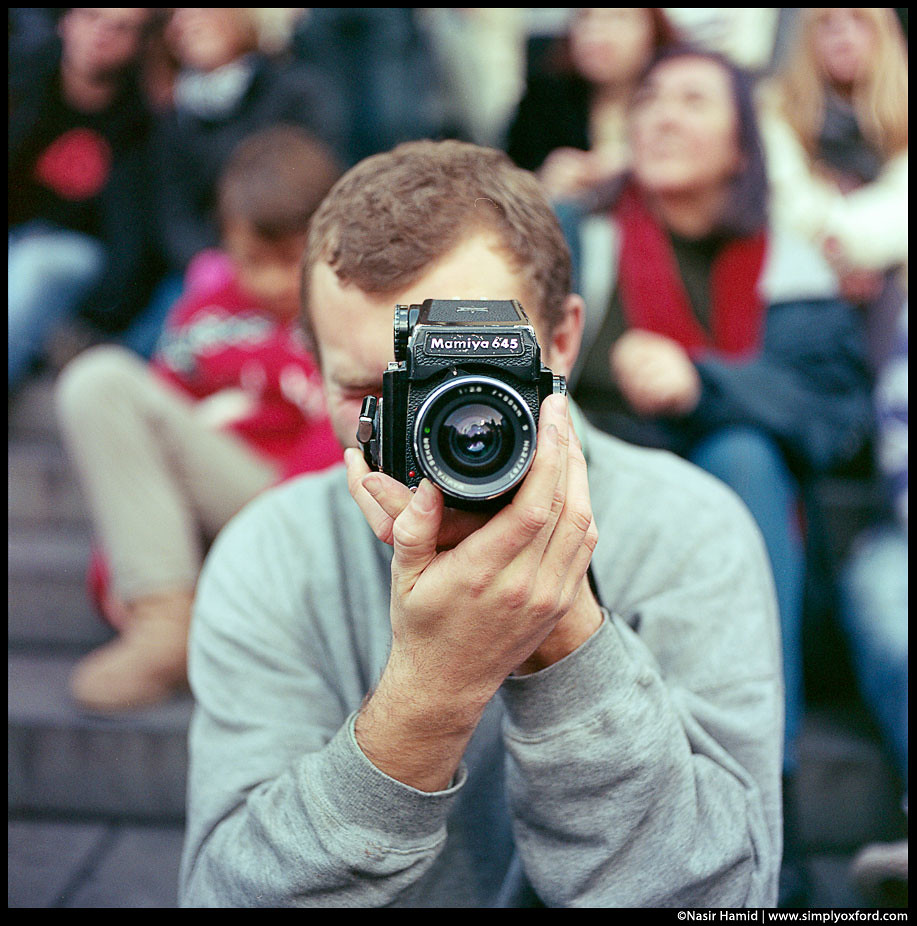 A man using a Mamiya M645 film camera