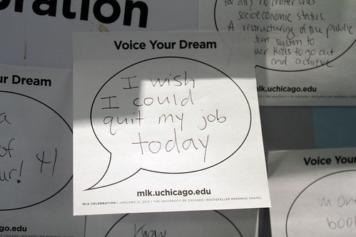 A wall of sticky notes that are pre printed with thought bubbles and the text "Voice You Dream" from mlk.uchicago.edu. The one in focus says "I wish I could quit my job today"