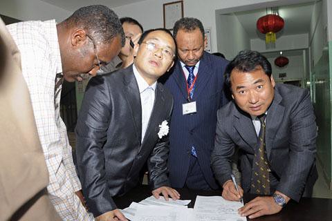 Members of the Chinese embassy in Sudan sign handover papers to receive the body of a worker killed in the kidnapping of specialists who were abducted by South Sudan rebels fighting the government in Khartoum. Despite the partition, fighting continues. by Pan-African News Wire File Photos