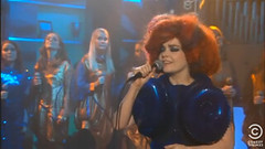 Screen Shot of Bjork on the Colbert Report, she is wearing a blue dress and has big red hair