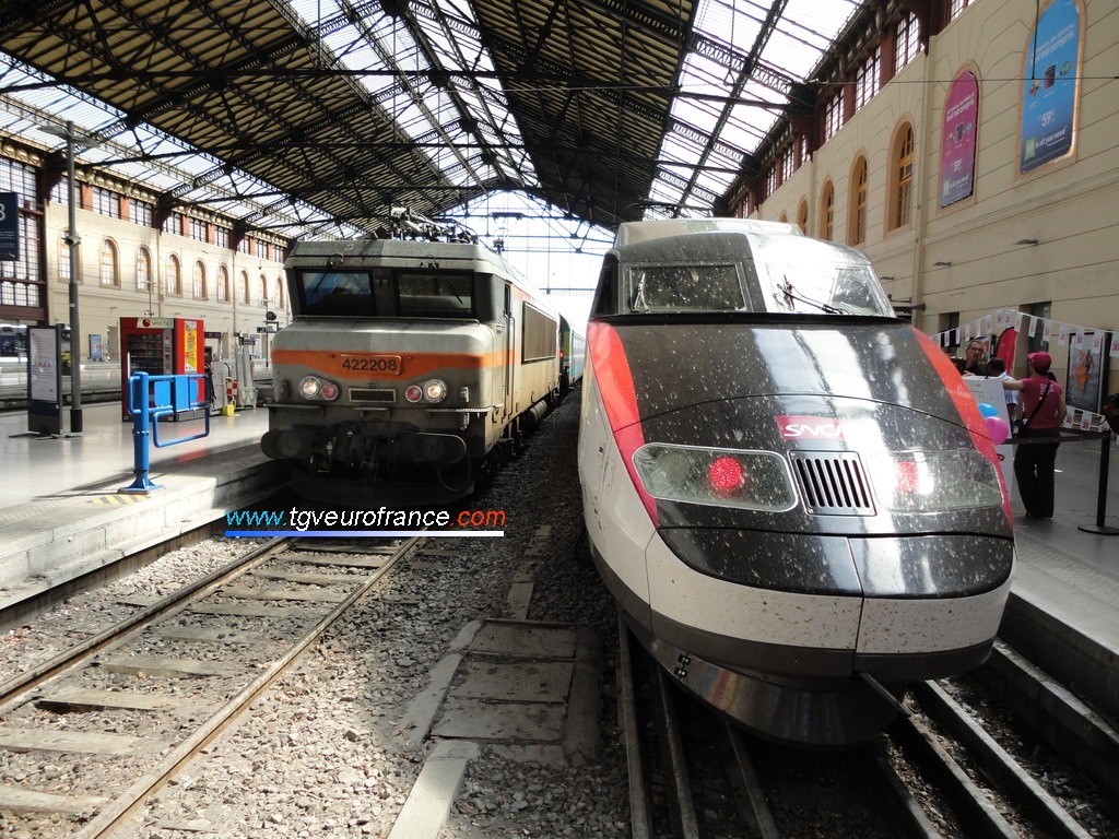 La locomotive électrique BB 22208 SNCF aux côtés de la rame TGV Sud-Est PSE 65 en gare de Marseille Saint-Charles