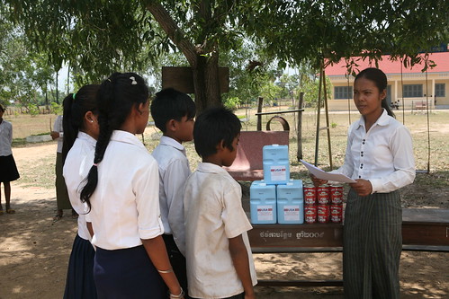 A teacher at Damnak Key School in Cambodia distributes take-home rations to students with good attendance records.  (Photo credit:  International Relief & Development)