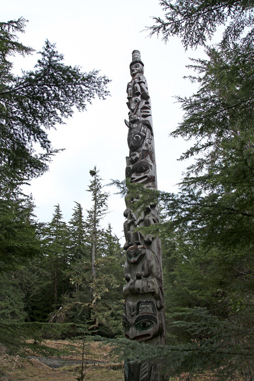 a totem pole among the trees in the Totems Historic District, Kasaan, Alaska