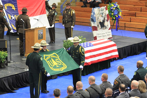 Honor Guard members begin to fold the U.S. Forest Service and North Carolina State flags during a memorial ceremony for Officer Jason Crisp and his K-9 partner Maros. (Courtesy of Mario Rossilli)