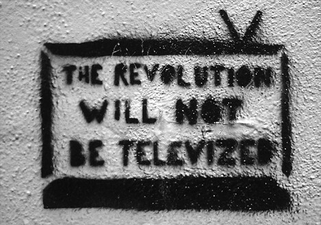 A black and white grafitti image of a rabbit eared tv set bearing the words "the revolution will not be televized" (sic)