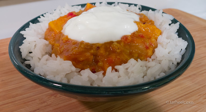 bowl of Sambar over rice with yoghurt on top