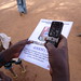 A beneficiary testing the SMS feedback system as they are given instructions to see if it works.