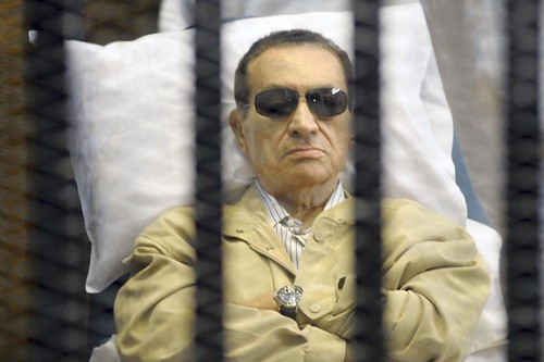 Egypt's ex-President Hosni Mubarak lays on a gurney inside a barred cage in the police academy courthouse in Cairo, Egypt, Saturday, June 2, 2012. by Pan-African News Wire File Photos