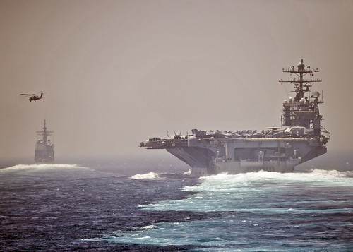 The aircraft carrier USS Abraham Lincoln (CVN 72), left, and the guided-missile cruiser USS Cape St. George (CG 71) transit the Strait of Hormuz.