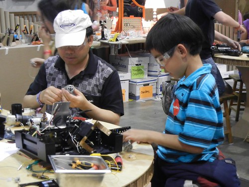 man and kid tinkering together