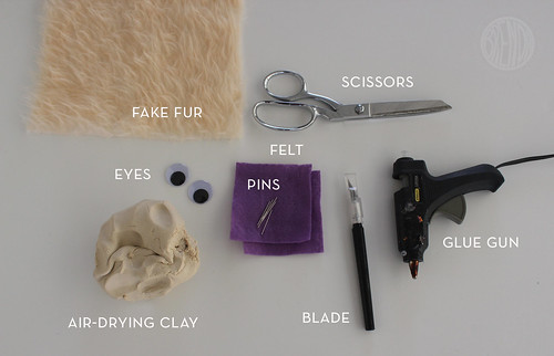 Supplies for Monster Phone Charger craft (fake fur, pins, eyes, clay, scissors, glue gun, blade)