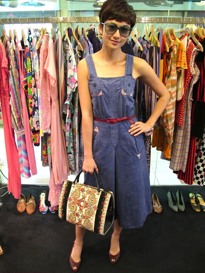  'Allo miss! Where you going? You look very chio leh.  We love this denim dress (Size S/M) with little plaid accents - comes with its own maroon skinny belt. Worn with Etienne Aigner slingback heels, a gorgeous embroidered bag from Western Germany, and green Mondi shades (NOS).