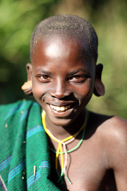 Ethiopia tribes Surma Suri people Young smiling girl seen in a village