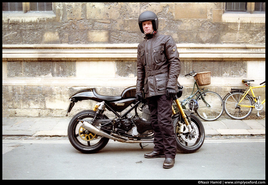Rupert Penry-Jones standing in front of a Norton Commando