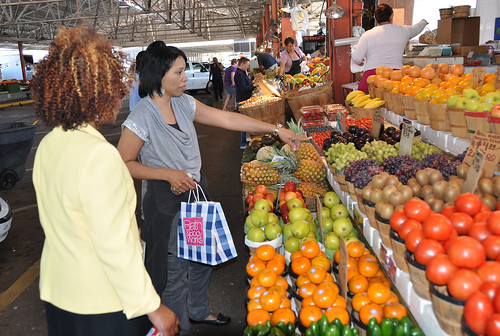 Food and Nutrition Service employees Jackie Garrett, right, and Angela Mathis, left, inquire about the price of grapes at a produce stand at the Dallas Farmers Market. 