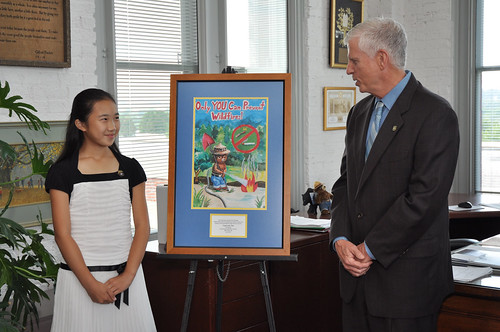 U.S. Forest Service Chief Tom Tidwell congratulates Caroline Tan, 11, of Westfield, N.J., for her award-winning poster she submitted in the Smokey Bear & Woodsy Owl Poster Contest. Her art, chosen the best among fifth graders who entered the contest, was named national winner from nearly 22,000 entries.