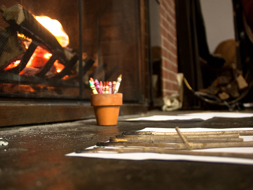 Photograph of crayons and charcoal pencils by a fireplace