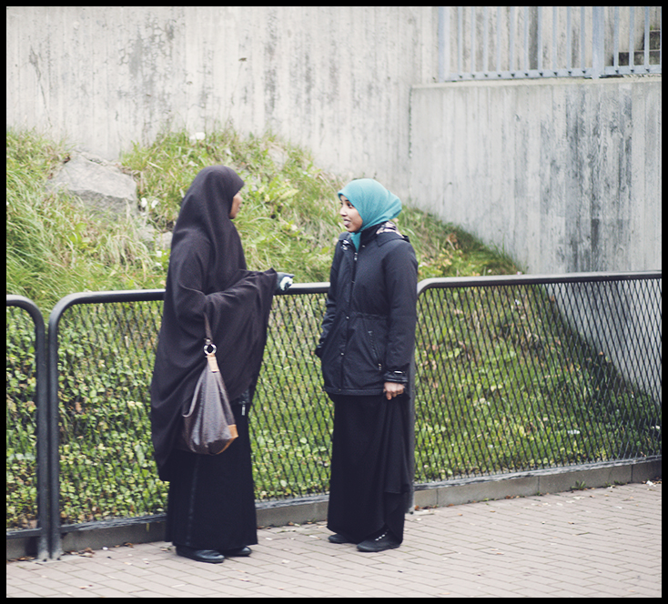 two muslim women chatting while waiting for the tram