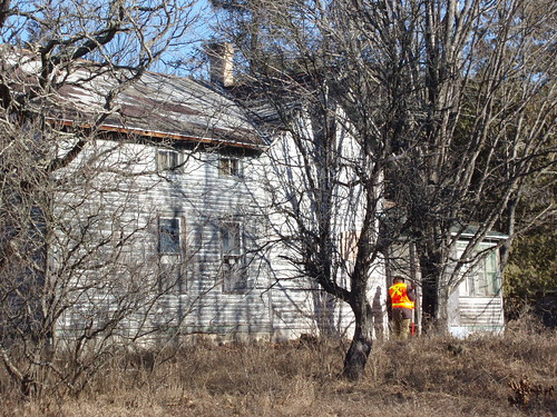 A worker carrying out a boundary survey, although it doesn’t look like this house has many neighbours with whom to have disputes!
