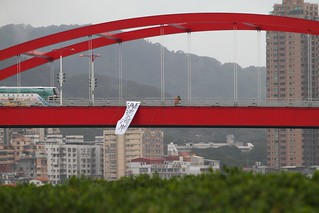 反對新建淡北快速道路，環團在關渡大橋垂下七公尺長「Save淡水河岸」的巨型抗議布條照片。（綠色公民行動聯盟提供）