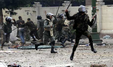 Egyptian police chase demonstrators on December 16, 2011. The police broke up an occupation near the government headquarters. by Pan-African News Wire File Photos