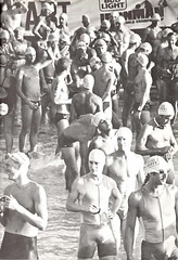 Swimmers milling about on the beach waiting for the race to start