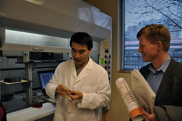 The Food Innovation Center’s Dr. Quingyue Ling shows USDA’s Max Finberg how new technology can laser-imprint tracking data on individual food items as small as a grain of rice at the center’s Radio Frequency Identification Lab. 