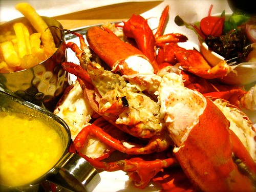 Grilled lobster with salad and chips and garlic butter