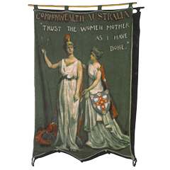 An Australian banner featuring two white women in robes that says TRUST THE WOMEN AS I HAVE DONE