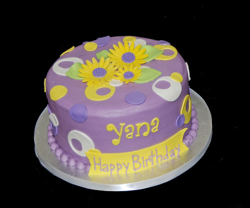 purple and yellow sassy circles birthday cake topped with whimsical daisies