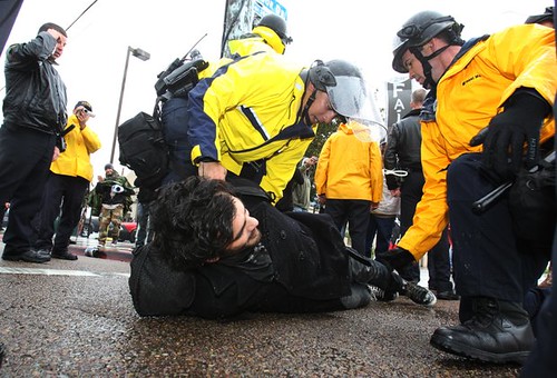 Cops hold down a peaceful activist in San Diego, California during a west coast demonstration aimed at shutting the ports. The events were a continuation of anti-capitalist Occupy manifestations. by Pan-African News Wire File Photos