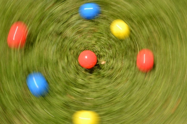 A photo where the movement of the camera creates an interesting blur effect - Coloured balls on grass