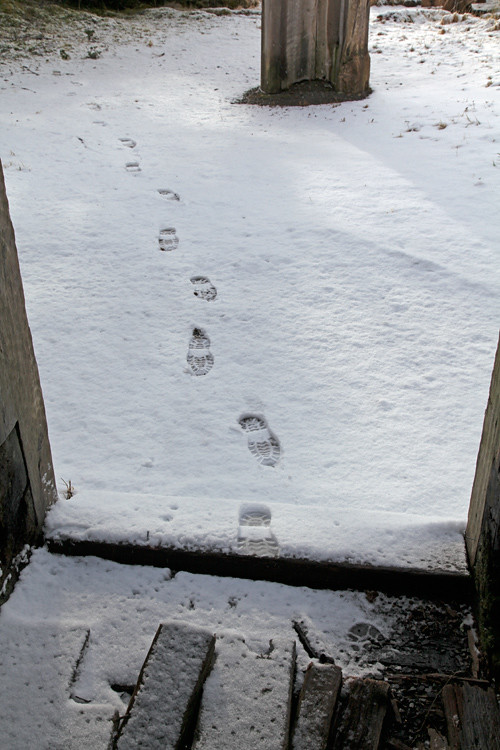 footprints in the snow going into Naay I'waans, Chief Son-i-Hat Whale House, Kasaan, Alaska