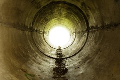 An industrial tunnel leading into the light