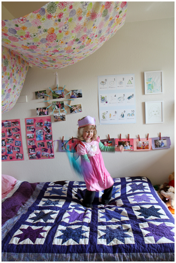 Butterfly princess daughter jumping and dancing on her bed, loving her room