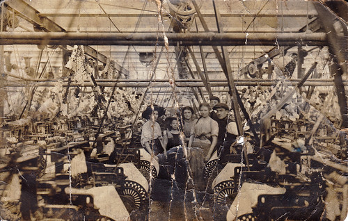 Workers amidst the looms in Oswaldtwistle textile mill, Oswaldtwistle, Lancashire. Decorated for the 1910 coronation.