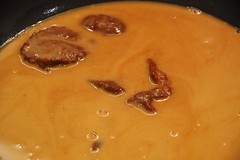 Añadimos la pasta de curry rojo en la salsa donde han cocido las cabezas y las pieles