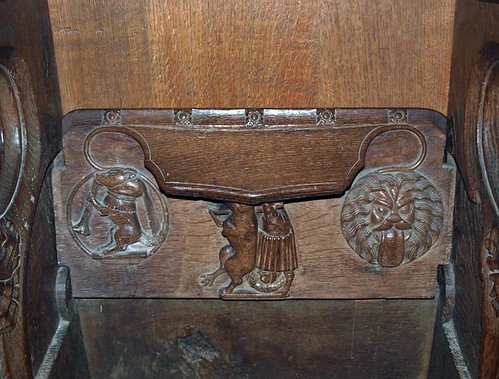 Misericord S5 Fox carrying a priest preceeded by a wolf blowing a trumpet & followed by a Lion's head with protruding tongue  (1)