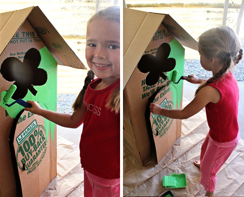 child painting cardboard house 
